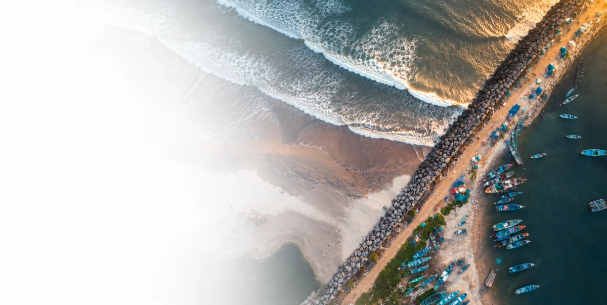 Aerial view of a breakwater and fishing boats along the Kerala coast